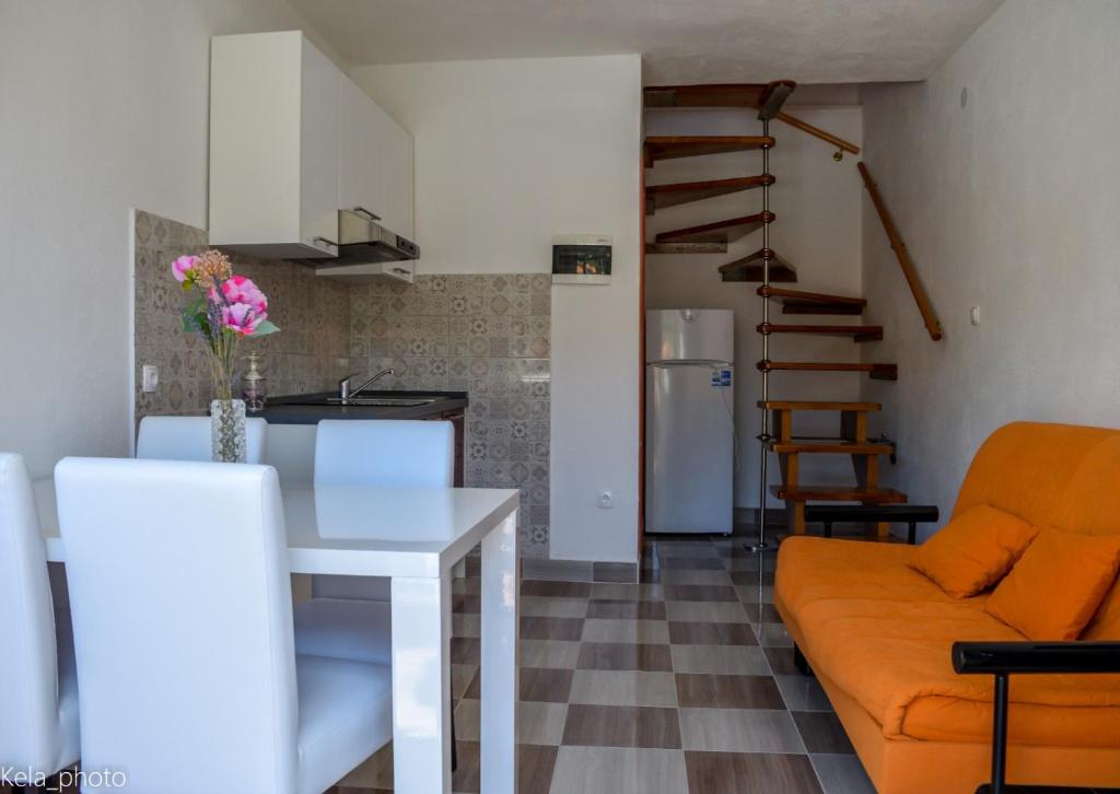 eine Küche und ein Wohnzimmer mit einem Sofa und einem Tisch in der Unterkunft Galeb 2 in Veli Iž