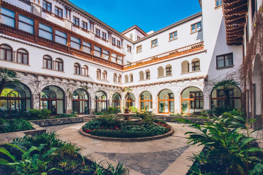 a courtyard of a large building with a fountain at Iberostar Heritage Grand Mencey in Santa Cruz de Tenerife