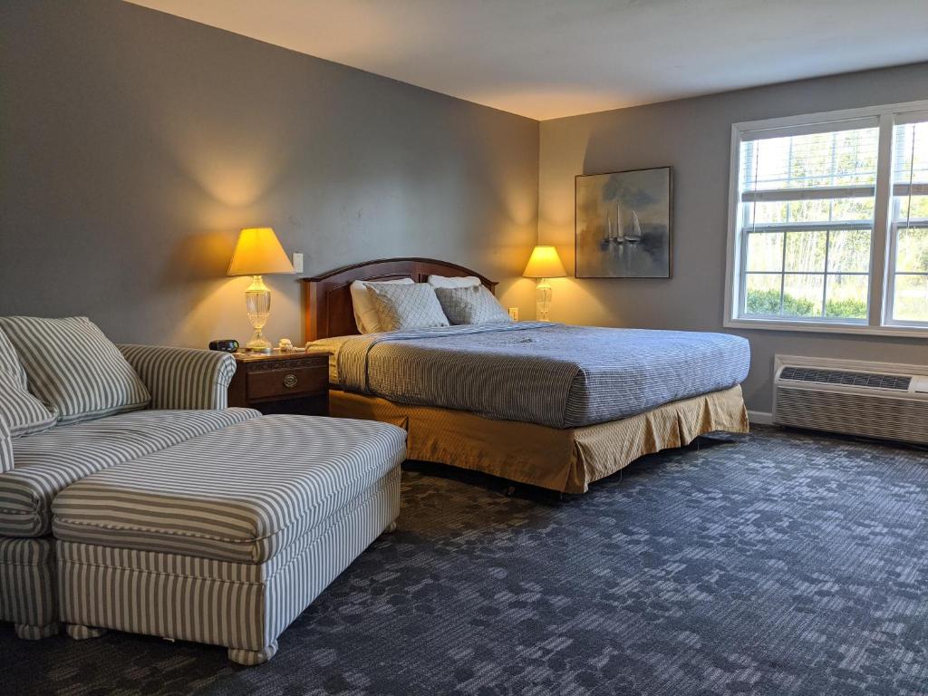 a bedroom with two beds and a couch and a window at Beach Harbor Resort in Sturgeon Bay
