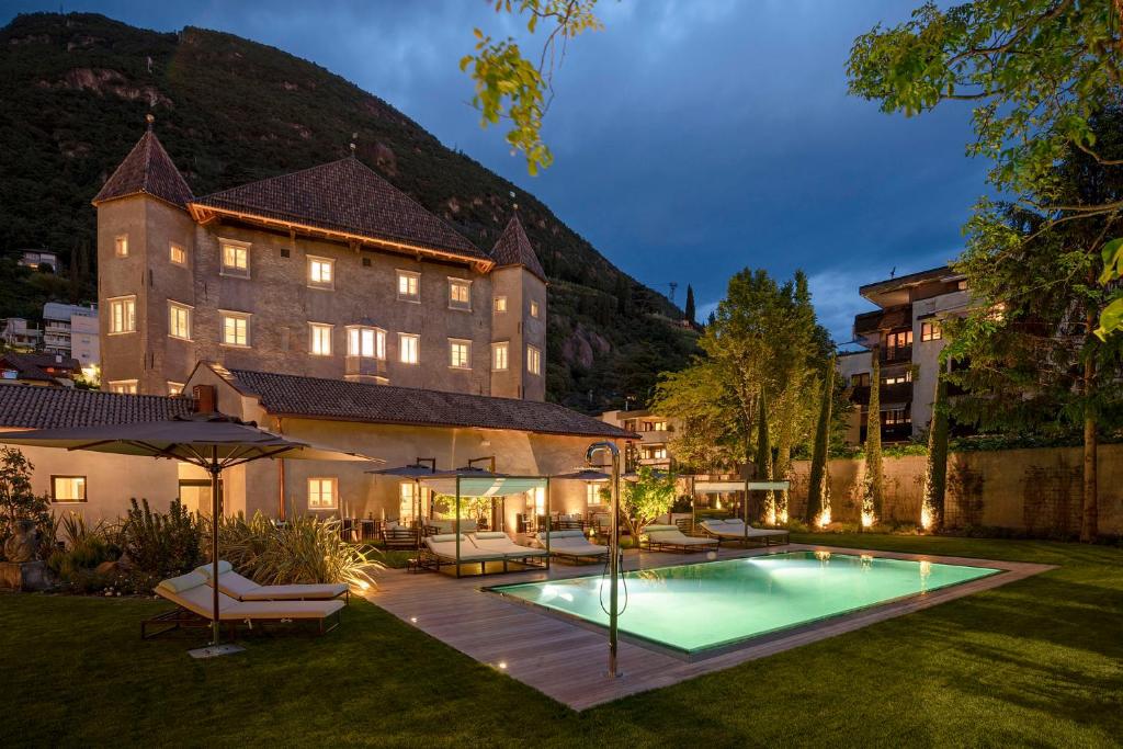 a hotel with a swimming pool in a yard at Castel Hörtenberg in Bolzano