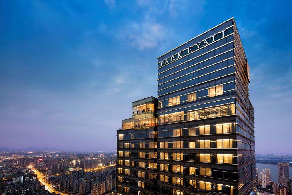 a tall office building with a view of a city at Park Hyatt Hangzhou in Hangzhou