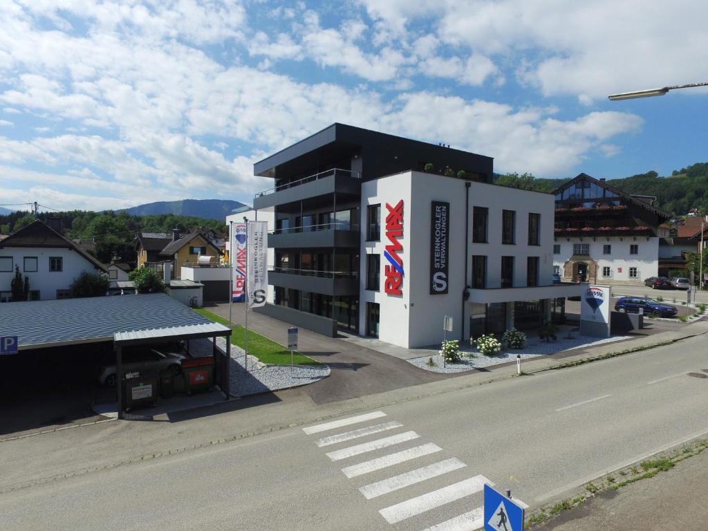 um grande edifício branco com um telhado preto numa rua em Ferienwohnungen Ebenzweier em Altmünster