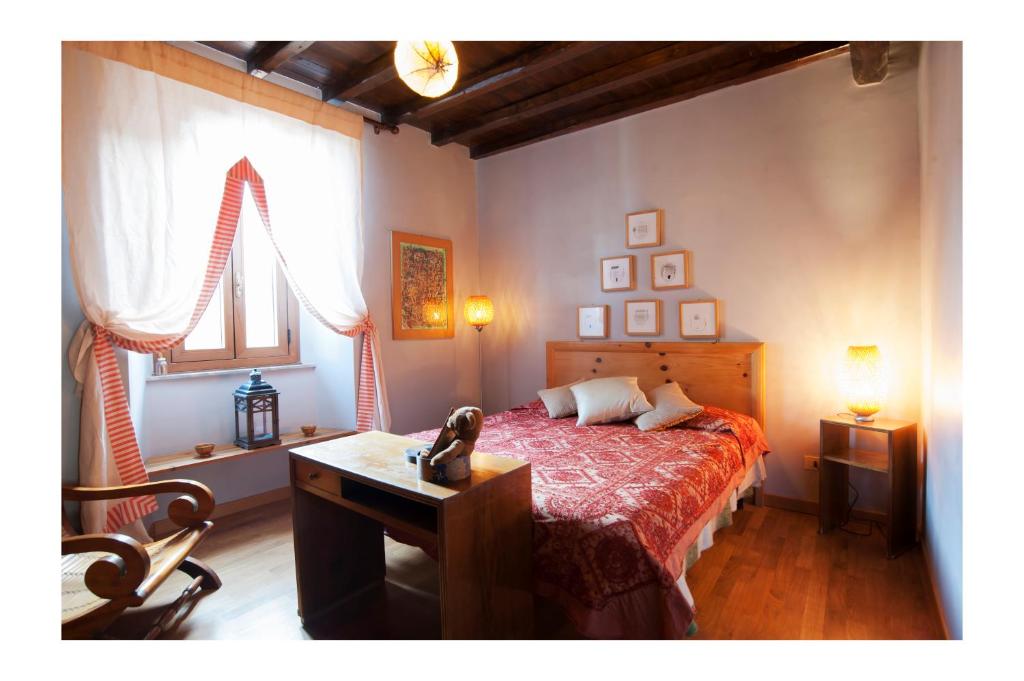 a bedroom with a bed and a desk and a window at A PALAZZO FORTEBRACCI B&B in Sutri