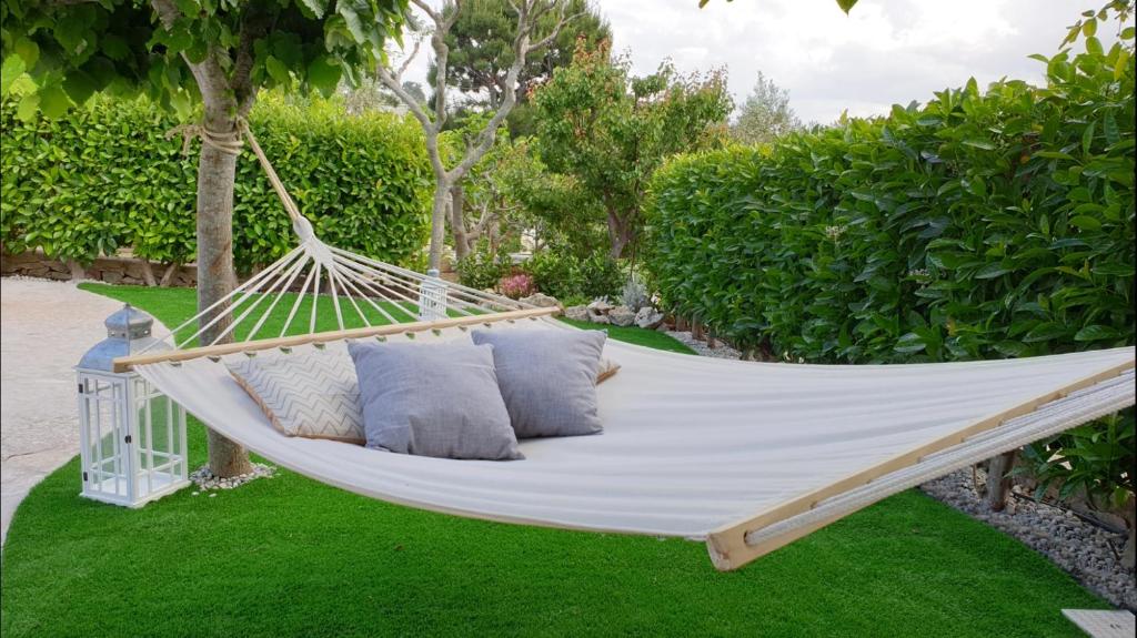 a white hammock with pillows in a garden at La Dimora del Colle in Fasano