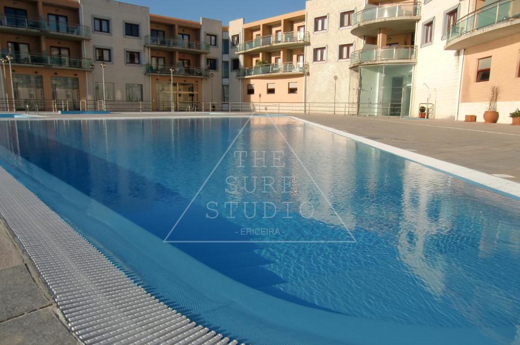 a swimming pool in front of some apartment buildings at The Surf Studio - Ericeira in Ericeira