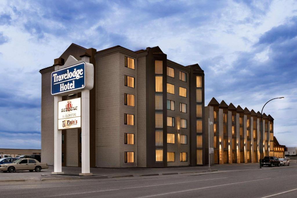 a building with a hotel sign on the side of it at Travelodge Hotel by Wyndham Saskatoon in Saskatoon