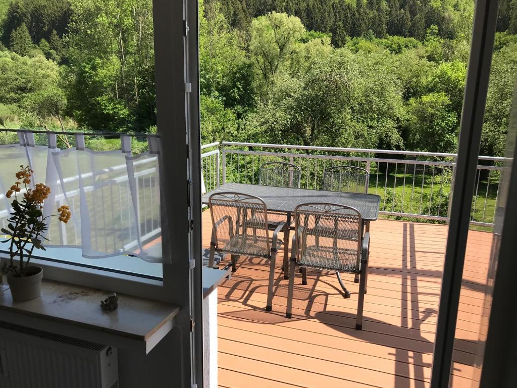 einen Balkon mit einem Tisch und Stühlen auf einer Terrasse in der Unterkunft Haus Kyllblick in Birresborn
