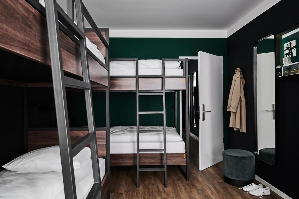 a bedroom with two bunk beds with a ladder at GRONERS Leipzig City Center in Leipzig