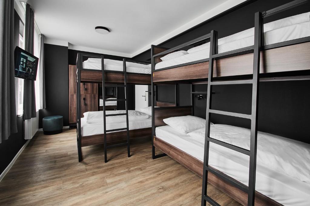 two bunk beds in a room with wooden floors at GRONERS Leipzig City Center in Leipzig