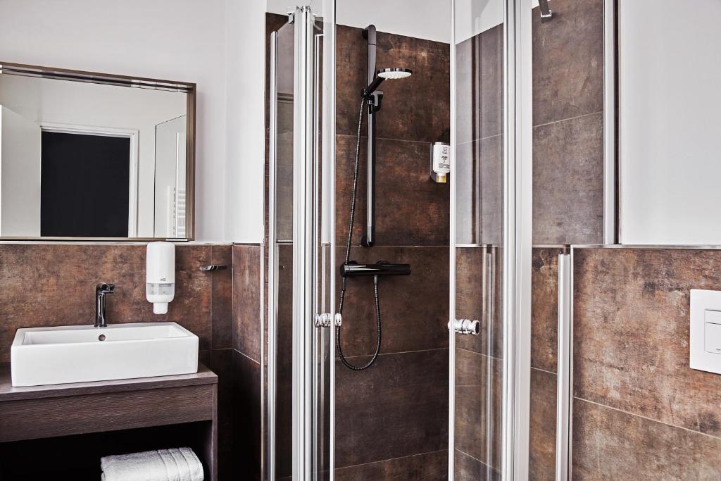 a bathroom with a shower and a sink at GRONERS Leipzig City Center in Leipzig