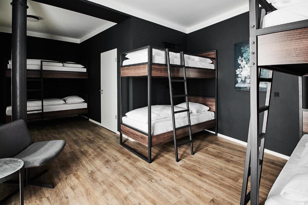 a room with three bunk beds and a couch at GRONERS Leipzig City Center in Leipzig