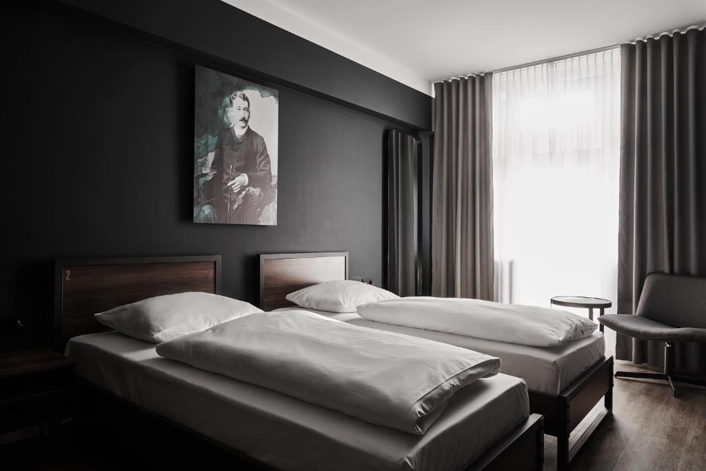 a bedroom with two beds and a window at GRONERS Leipzig City Center in Leipzig