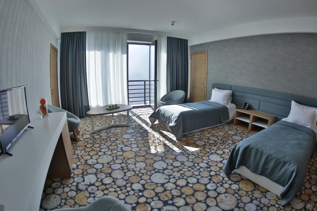 ein Hotelzimmer mit 2 Betten und einem Balkon in der Unterkunft Yurd Hotel in Qax