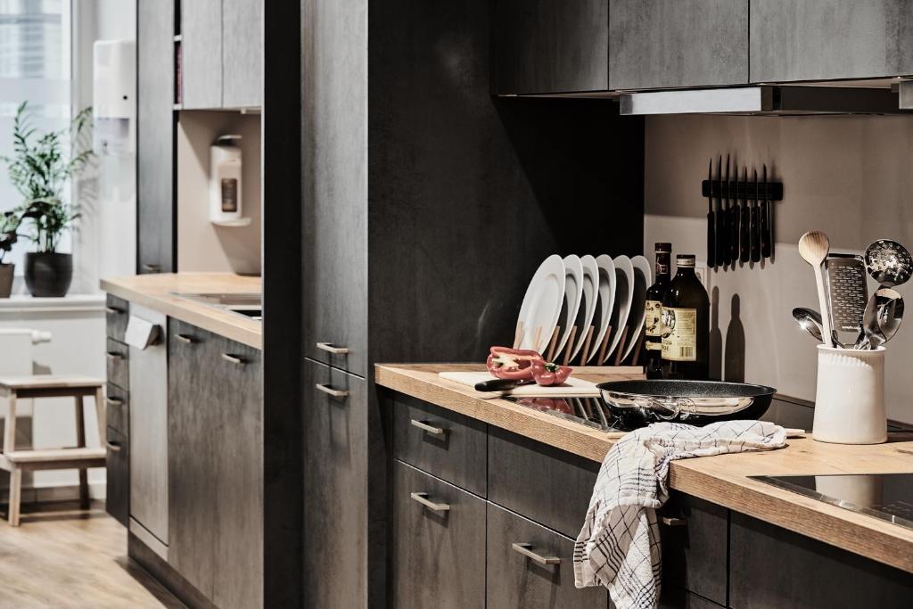 a kitchen with wooden cabinets and a counter top at GRONERS Leipzig City Center in Leipzig
