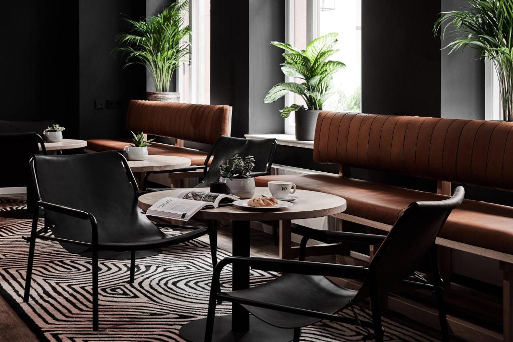 a restaurant with tables and chairs and plants at GRONERS Leipzig City Center in Leipzig