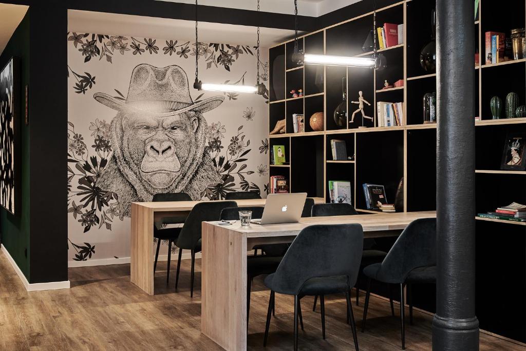 a room with a table with a monkey on the wall at GRONERS Leipzig City Center in Leipzig