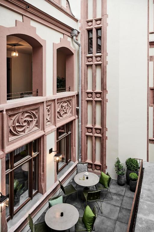a patio with two tables and chairs in a building at GRONERS Leipzig City Center in Leipzig