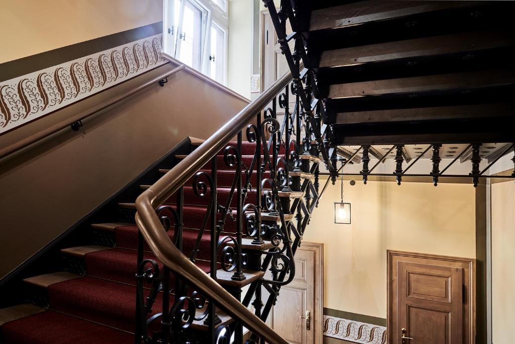 a staircase in a house with red carpeting and aintendent at GRONERS Leipzig City Center in Leipzig