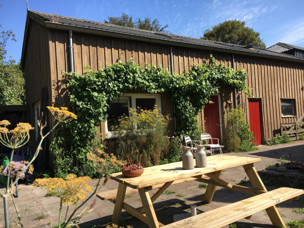 einem Picknicktisch aus Holz vor einem Gebäude in der Unterkunft B&B HemeltjeLief in Hemelum