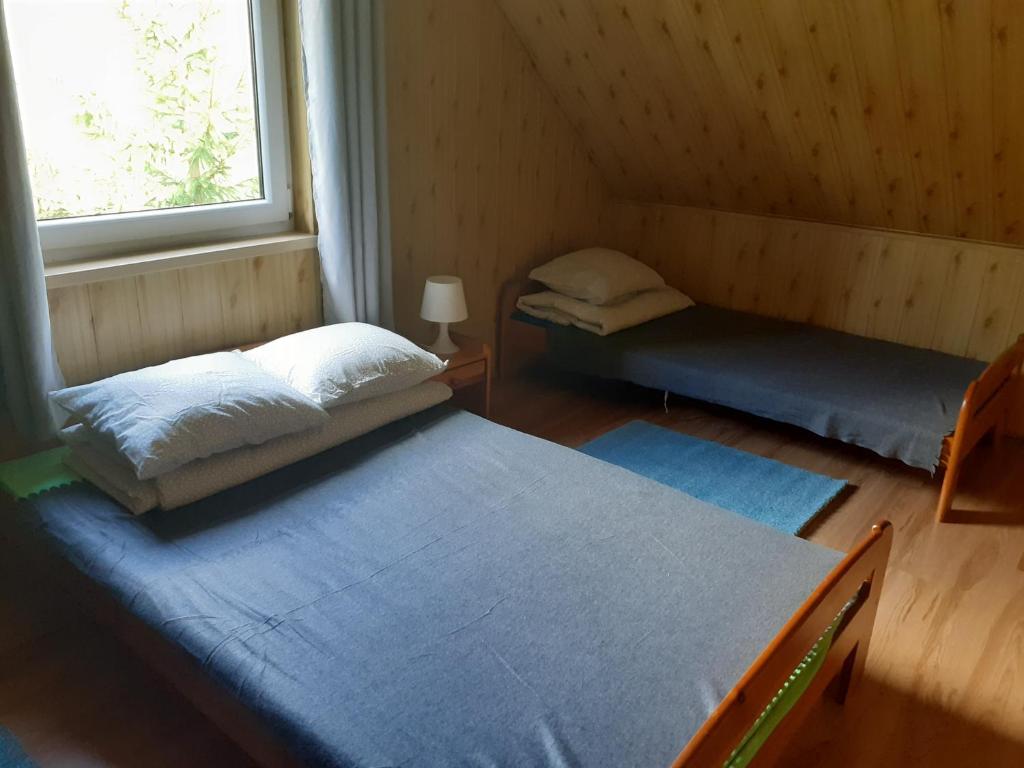 a room with two beds and a window at Siedlisko Bieszczadzkie 1 in Lutowiska