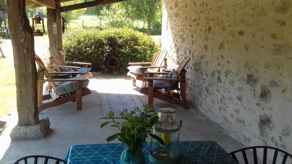 um pátio com cadeiras e uma mesa com uma planta em Rimbes Casteljaloux - gite 6 pers Rustique em Casteljaloux