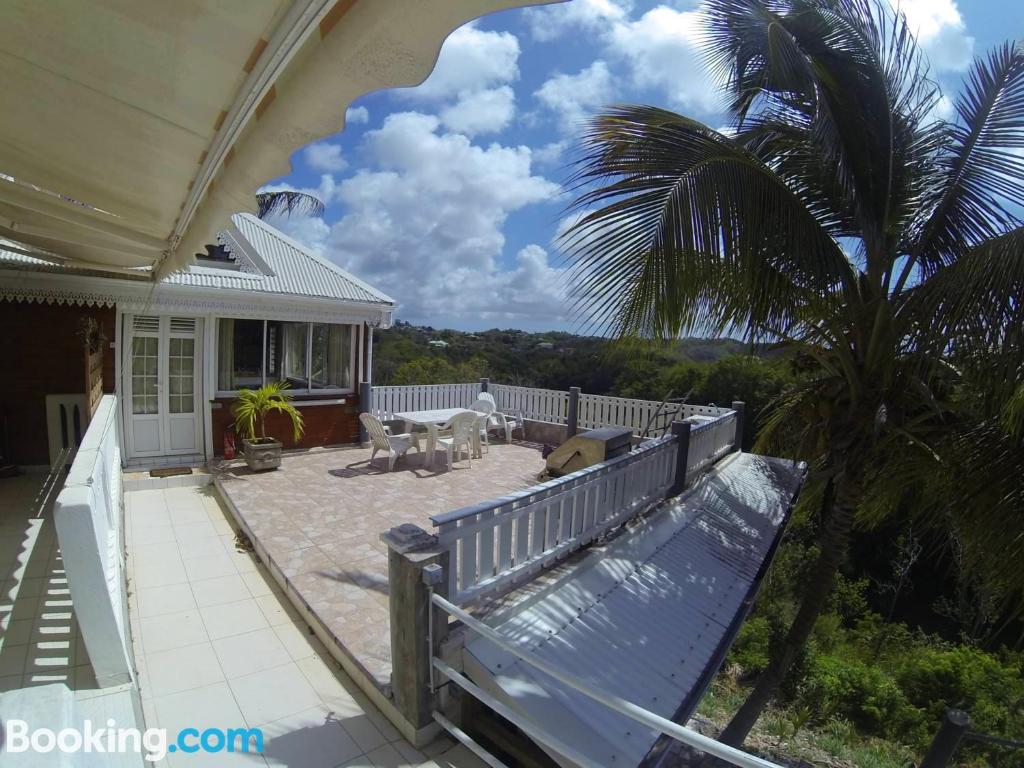 a porch of a house with a palm tree at Studio avec terrasse amenagee et wifi a Le Gosier a 3 km de la plage in Le Gosier