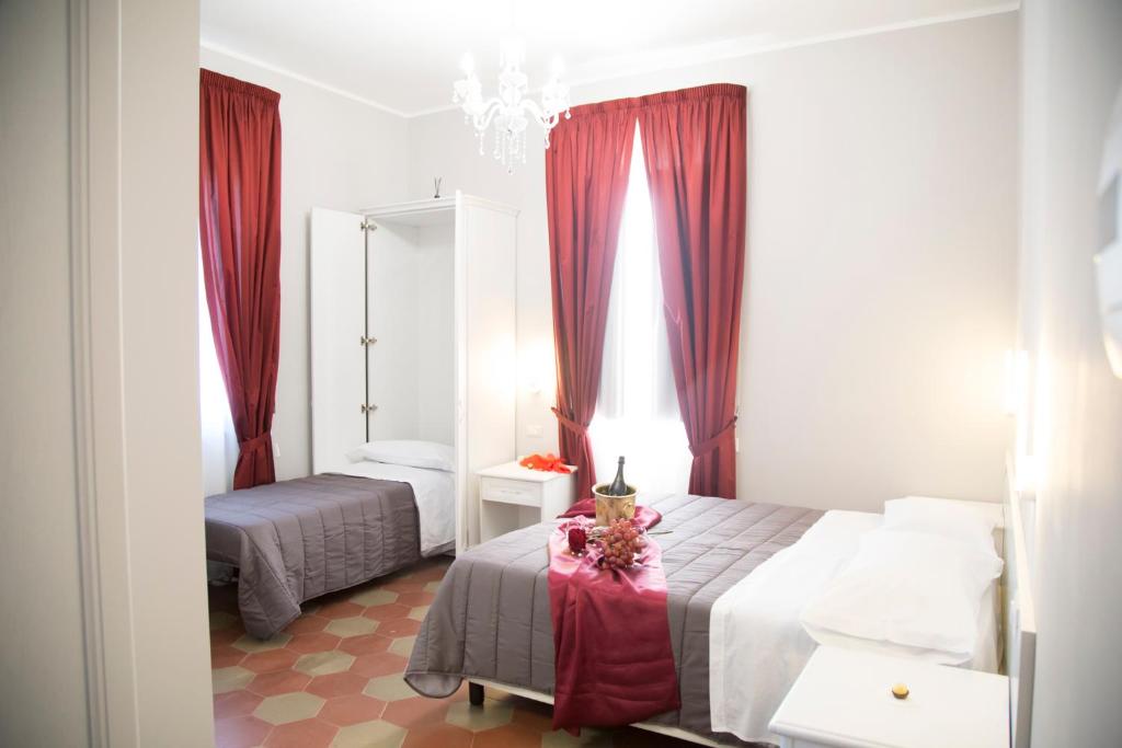 1 Schlafzimmer mit 2 Betten und roten Vorhängen in der Unterkunft Il Teatro B&B in Marina di Gioiosa Ionica