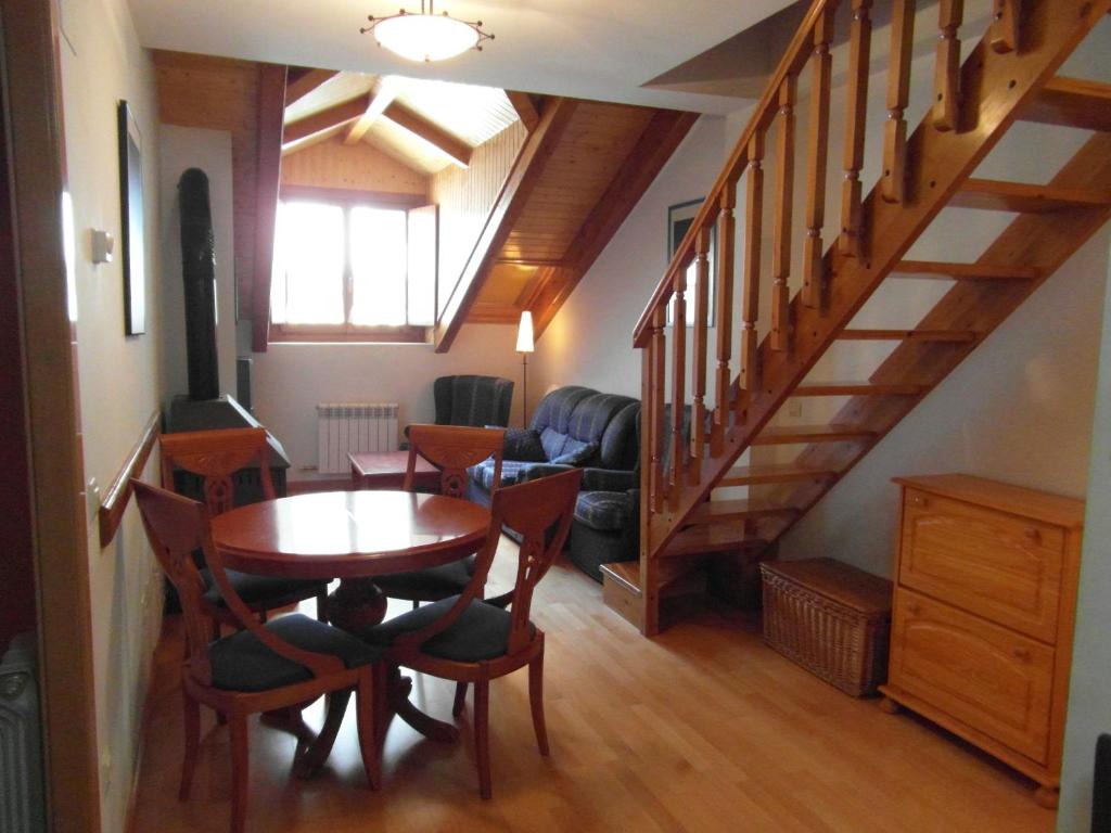 una sala de estar con una mesa de madera y escaleras en B47 - Casa Chispa Dúplex - Villmor, en Benasque