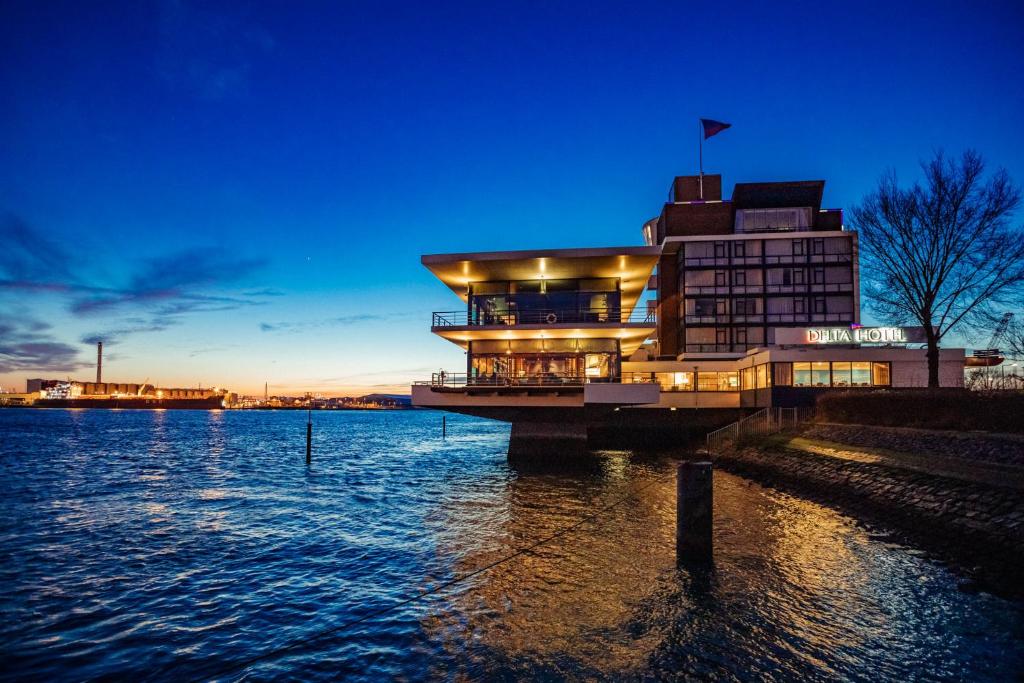 een gebouw op een pier naast een waterlichaam bij Delta Hotel in Vlaardingen