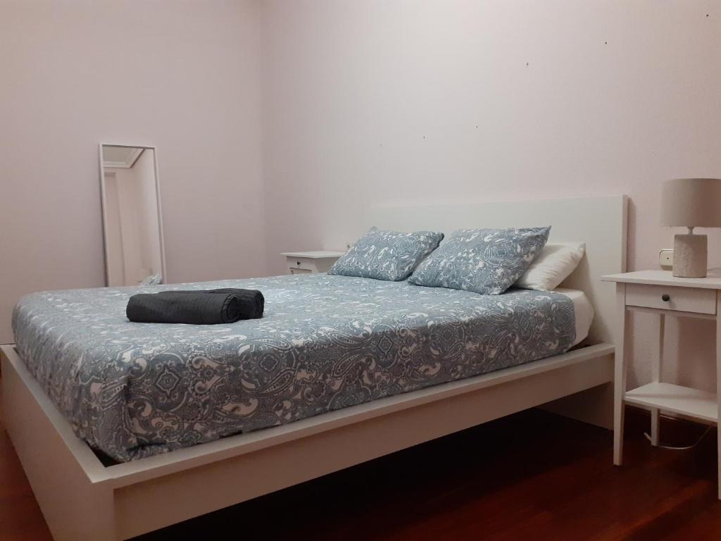 um quarto com uma cama com lençóis e almofadas azuis em Casa Centro em San Sebastián