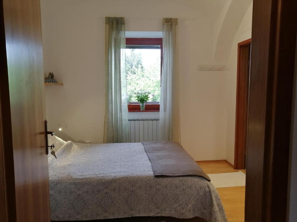 a bedroom with a bed in front of a window at City center blue sky house in Postojna