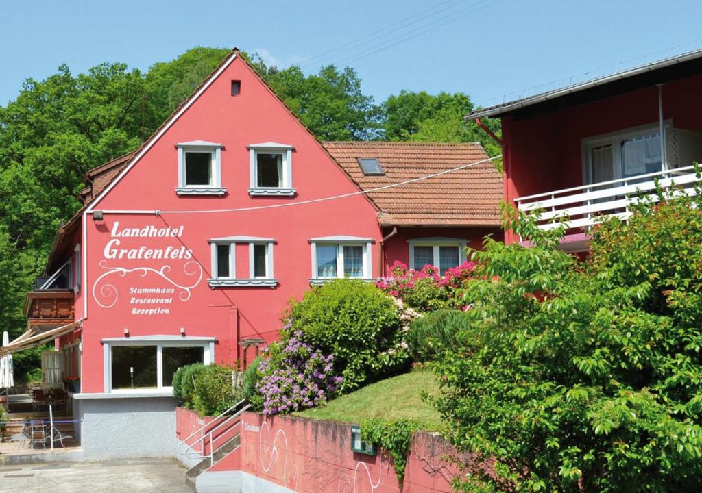 una casa roja con una valla delante en Landhotel Grafenfels, en Lemberg