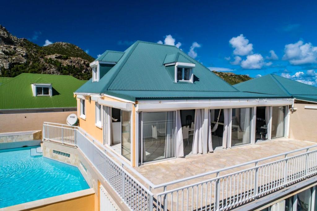 a house with a swimming pool and a green roof at 2 bedrooms villa at Saint Barthelemy 500 m away from the beach with sea view private pool and terrace in Saint Barthelemy