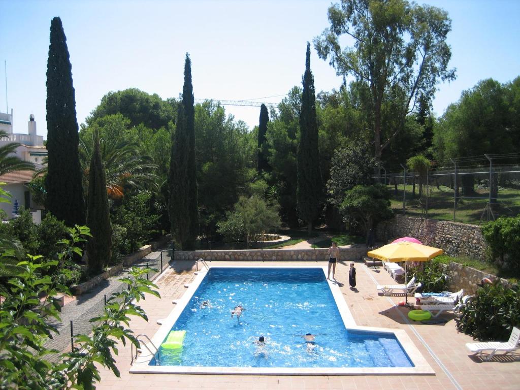a swimming pool in a garden with trees at Can Torrents in Cunit