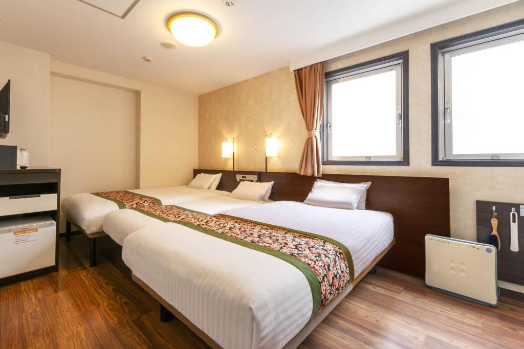 Postel nebo postele na pokoji v ubytování Dotonbori Hotel