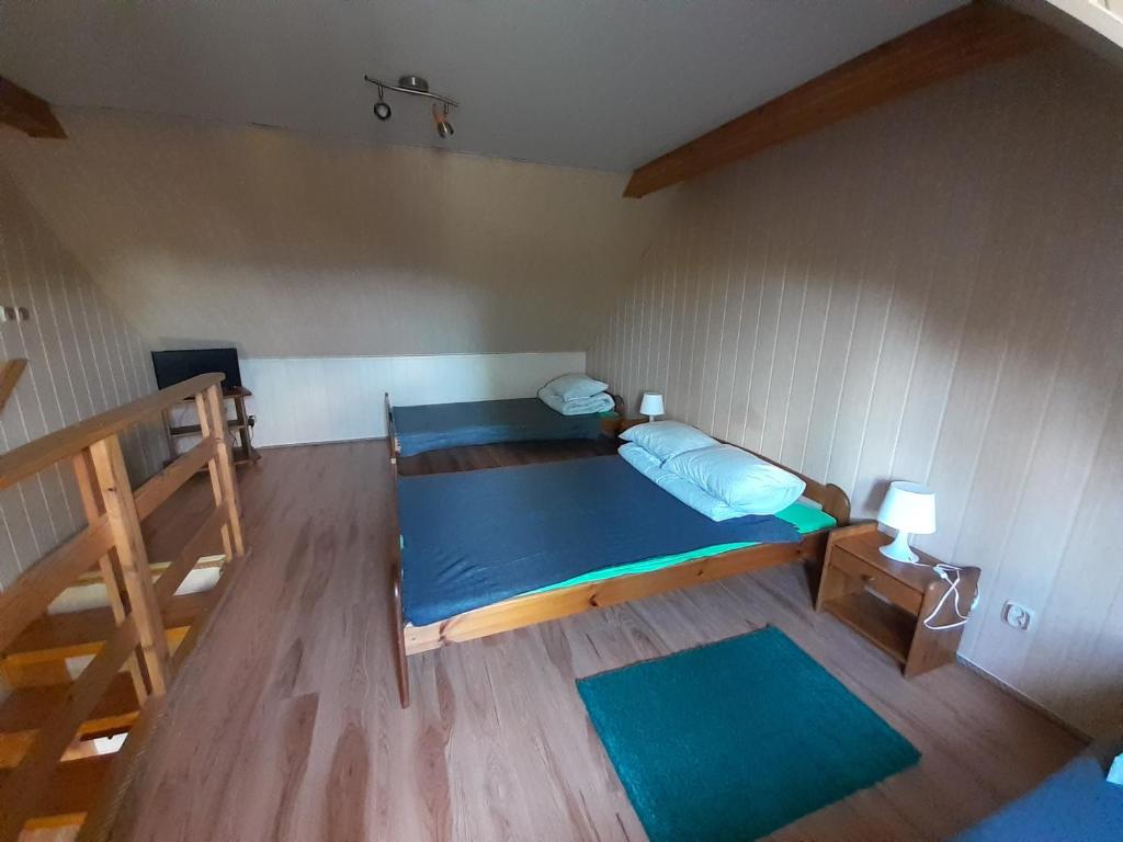 a small room with a blue bed and a wooden floor at Siedlisko Bieszczadzkie 2 in Lutowiska