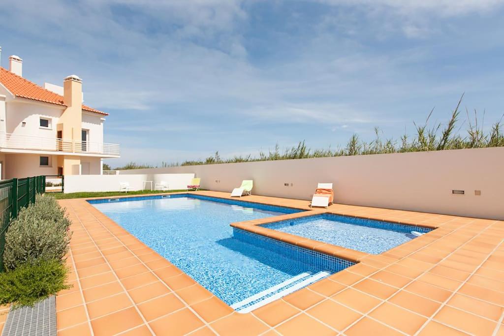a swimming pool in the backyard of a house at Casa Sardinha - Praia e Piscina - T2 (6 pessoas) in Ferrel