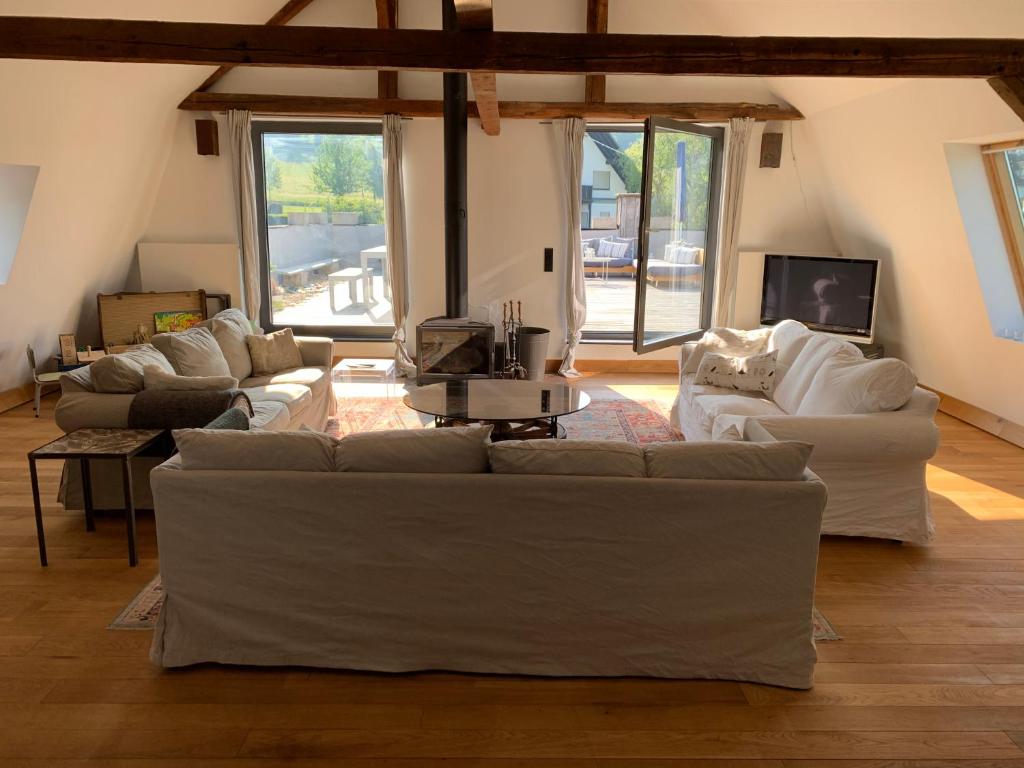 a living room with white couches and a tv at Design Appartment with big Terrace in Halsenbach