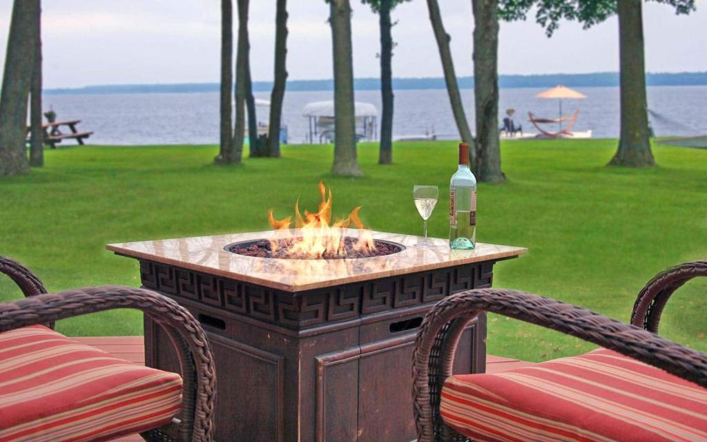 a fire pit with a glass of wine and two chairs at Leech Lake Resort Bed & Breakfast in Walker