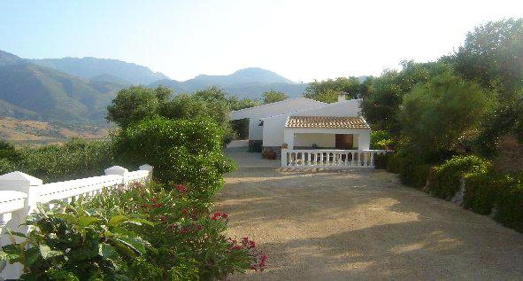 een wit huis met een hek en wat struiken bij 2 bedrooms chalet with lake view furnished terrace and wifi at El Gastor in El Gastor