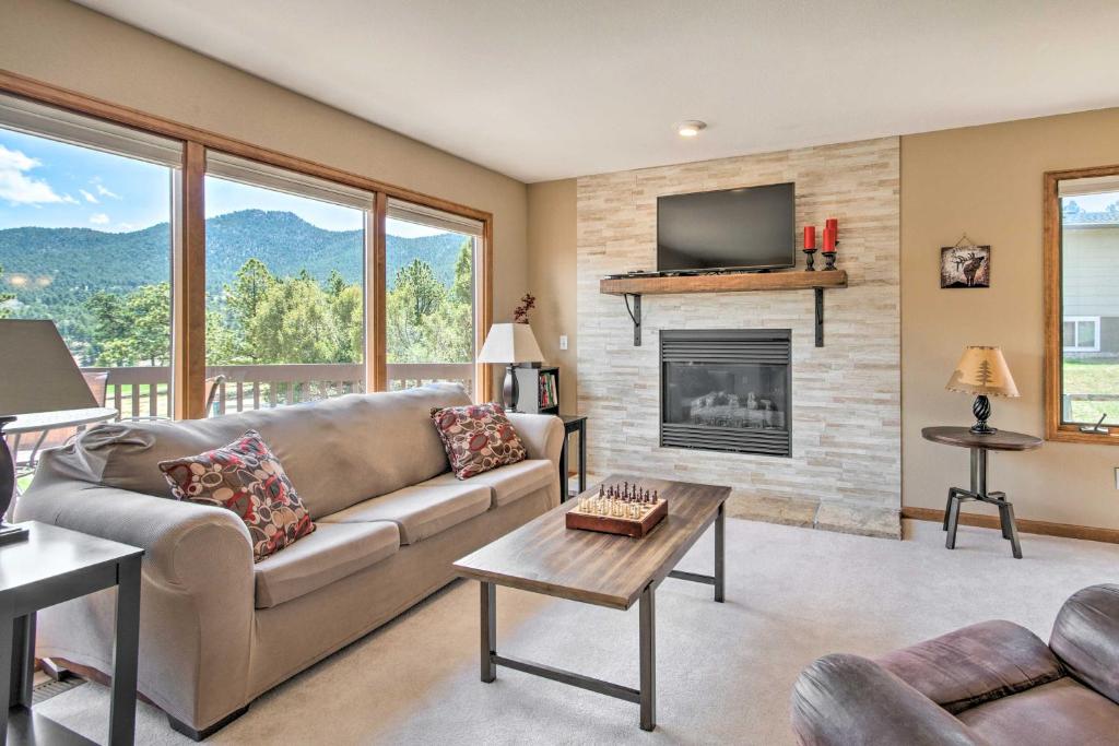 een woonkamer met een bank en een open haard bij Fireplace and Mtn Views Estes Park Home with Deck! in Estes Park