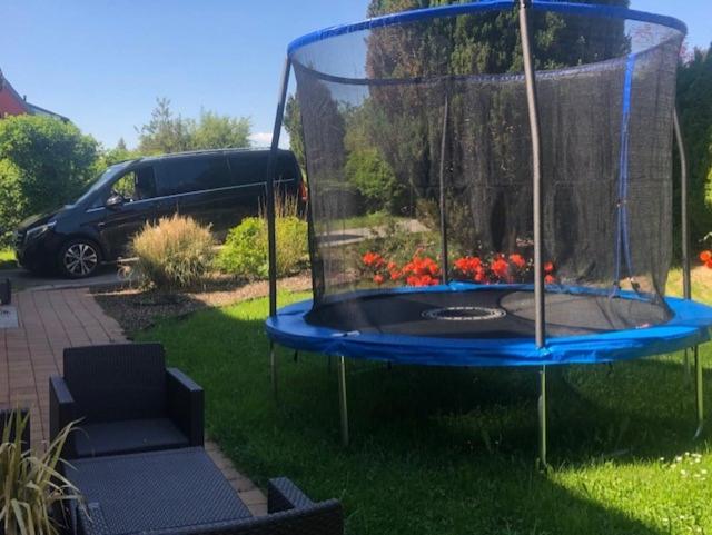 a batting cage in a yard with a car in the background at Gästehaus Luksch in Freyung