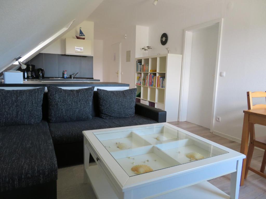 ein Wohnzimmer mit einem Sofa und einem Tisch in der Unterkunft Ferienwohnung Herzmuschel in Cuxhaven
