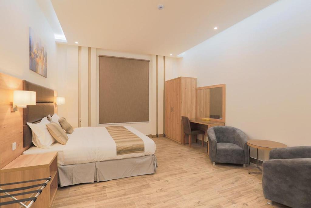 a hotel room with a bed and a desk at الوادي للوحدات السكنية in Riyadh Al Khabra