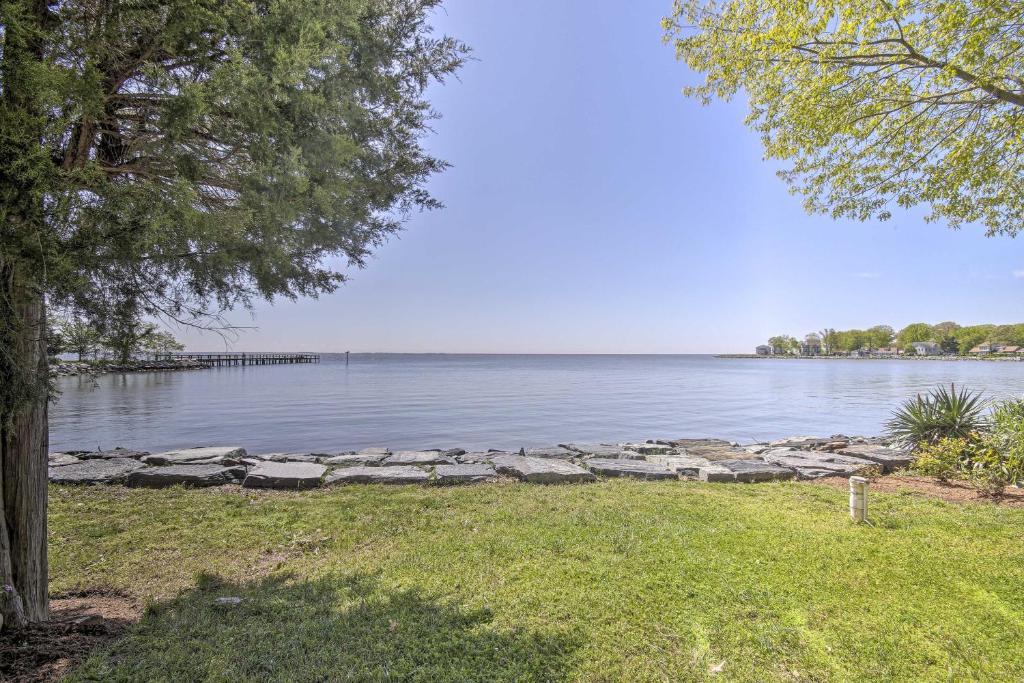 uma vista para um lago com uma parede de pedra em Luxe Chesapeake Bay Getaway Less Than 20 Mi to Annapolis! em Shady Side