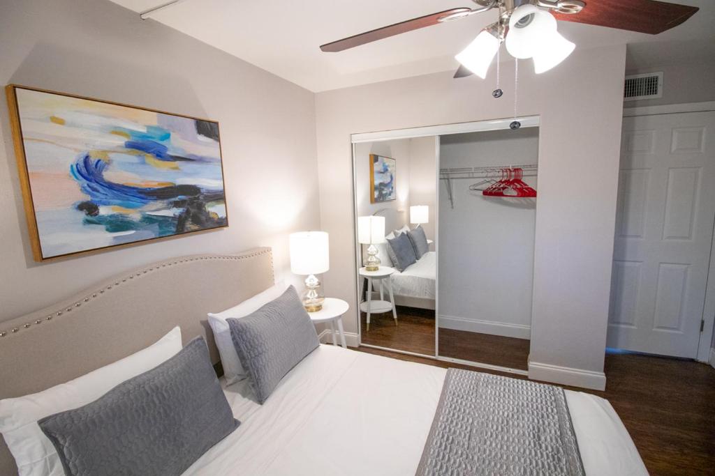 a bedroom with a white bed and a ceiling fan at The Victor Apartments By Lowkl in Fort Lauderdale