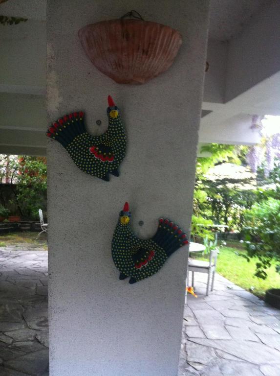 a wall with three rooster decorations on it at B&B Le Ortensie -Lago di Como in Lierna