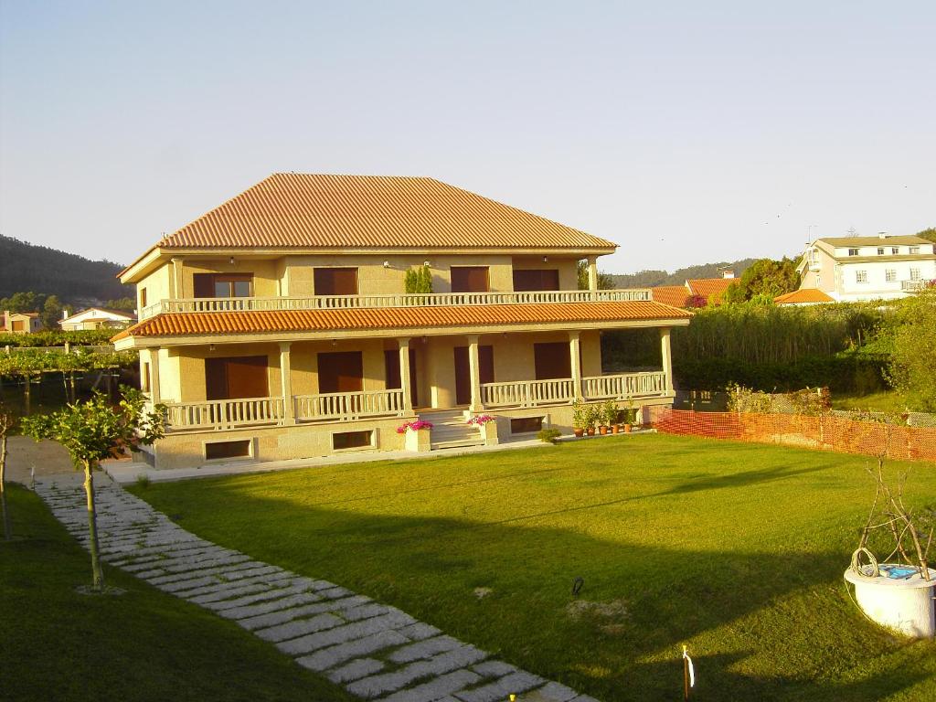 una casa grande con un patio grande con una casa en CASA DE AREAS, en Sanxenxo