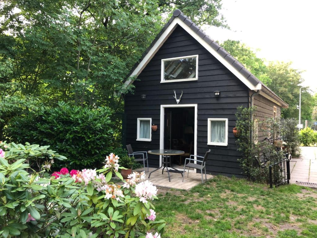 a black tiny house with a table in the yard at Cozy Cottage in Utrecht