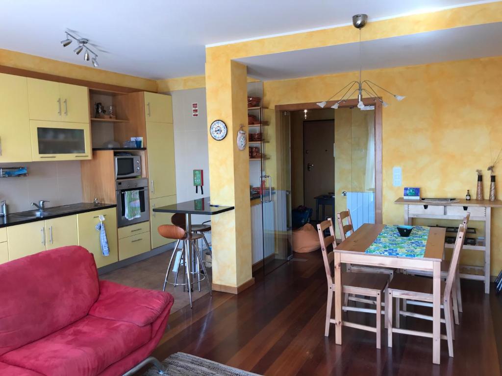 拉夫拉斯的住宿－Lavra Sea & Sun Beach Apartment (up to 4 guests)，客厅以及带红色沙发和桌子的厨房。